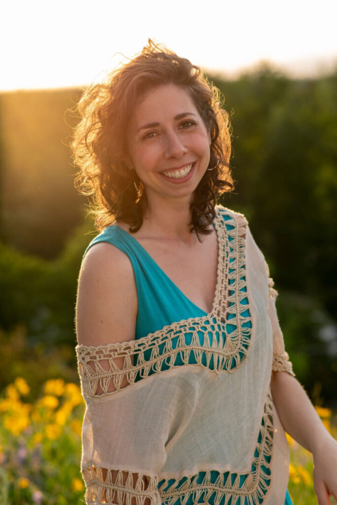 Photo of Amber smiling outdoors with alpenglow behind her